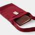 Red fabric pouch with a brown leather wallet inside on a white background