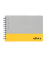Notebook with gray top half and yellow bottom half, featuring the brand 'utöka'.