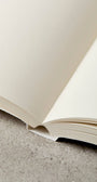 Notebook open laying flat with plain paper