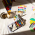 Colorful watercolor set with paint swatches on a light surface