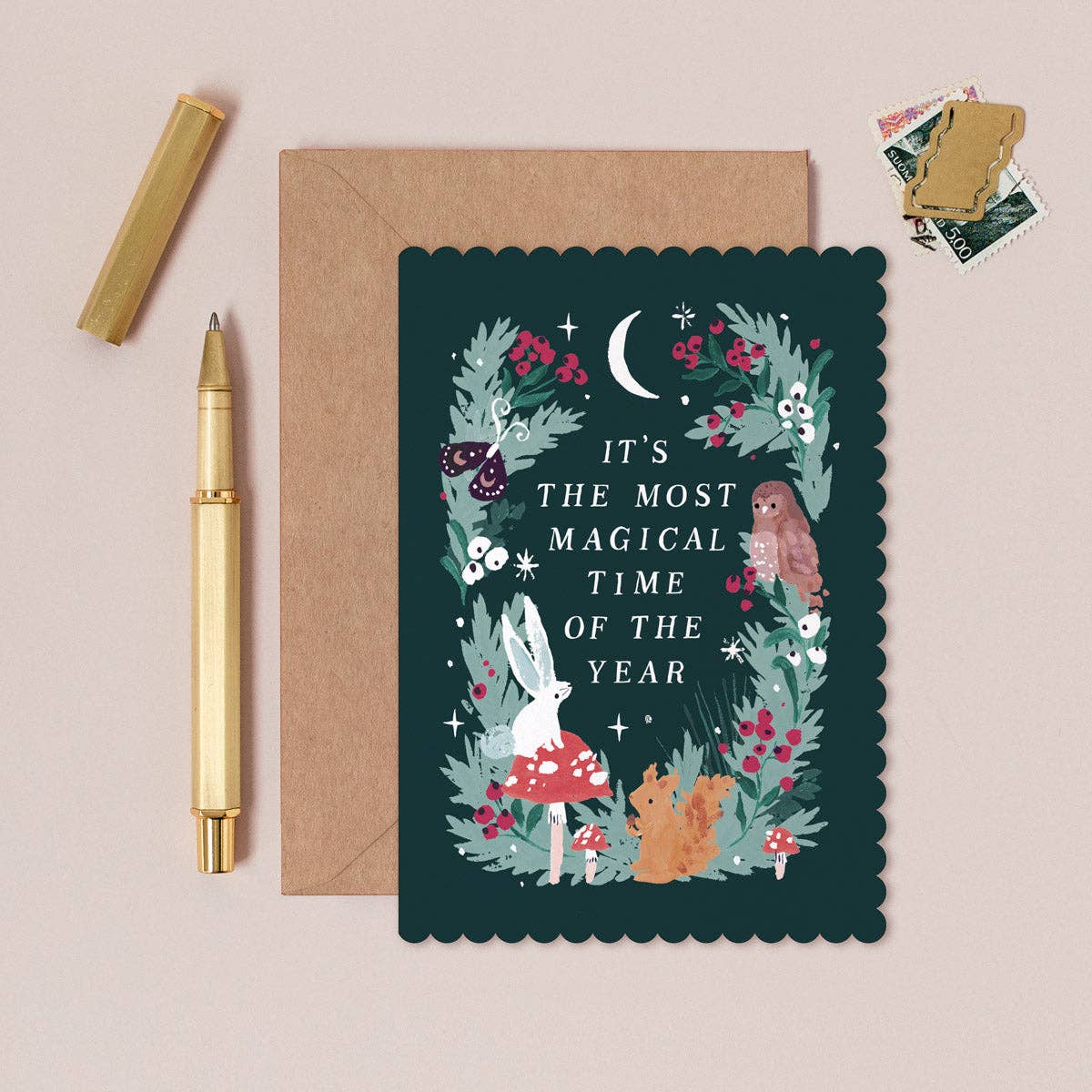 Greeting card with floral design and text, envelope, and pen on a beige background