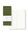 Green notebook with a ruled lines on the cover and ruled  pages open on a white background