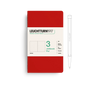 Red notebook with white label featuring Leuchtturm1917 branding and a pen on a white background