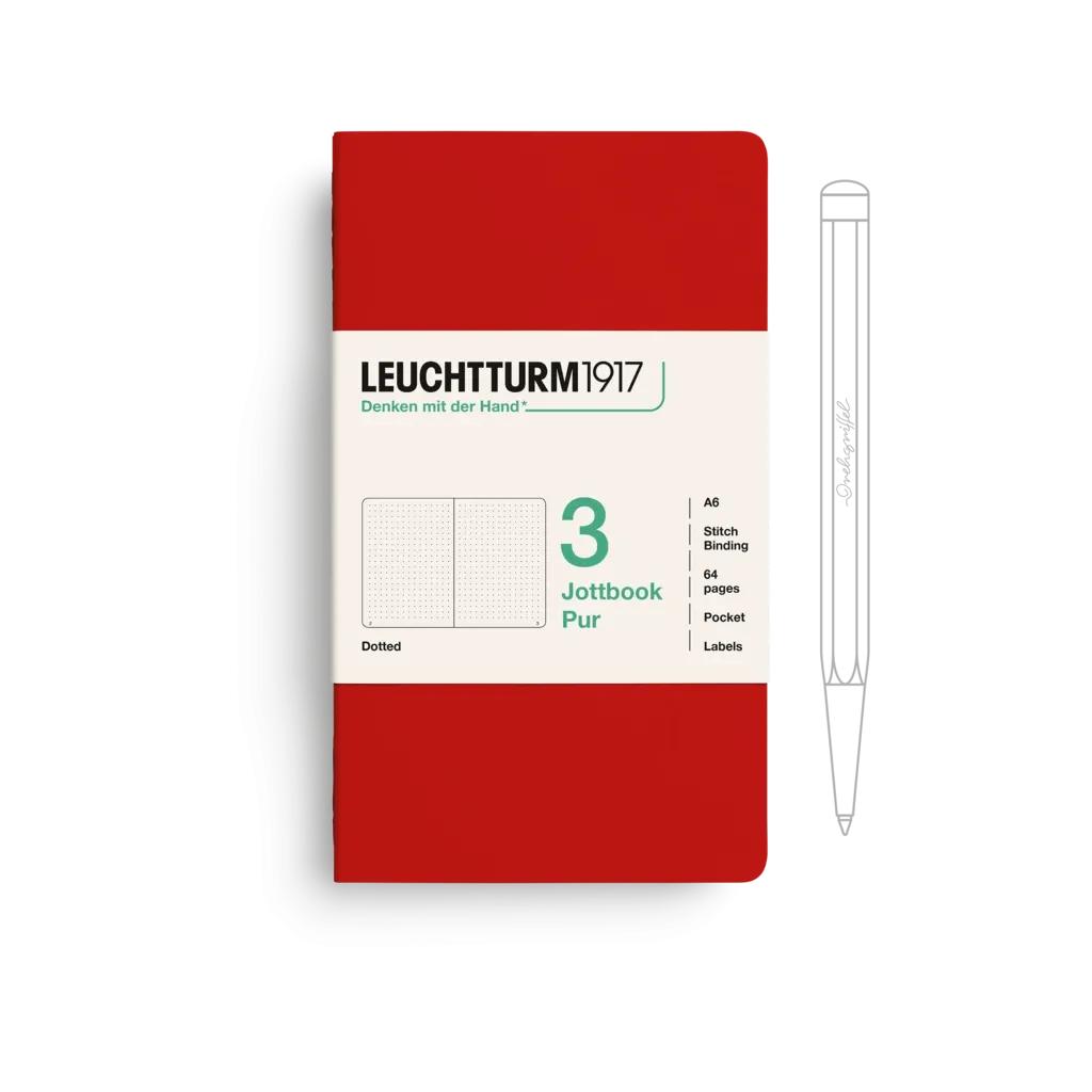 Red notebook with white label featuring Leuchtturm1917 branding and a pen on a white background