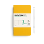 Yellow notebook with white label and pen on a white background