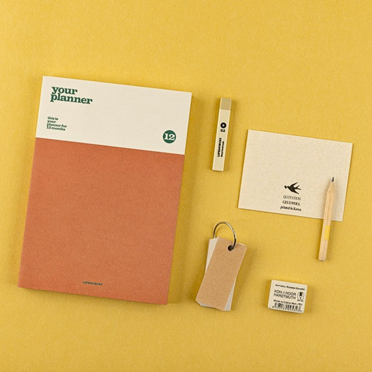Notebook, pen, and other stationery items on a yellow background