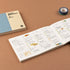 Open planner with colorful tape on a brown surface