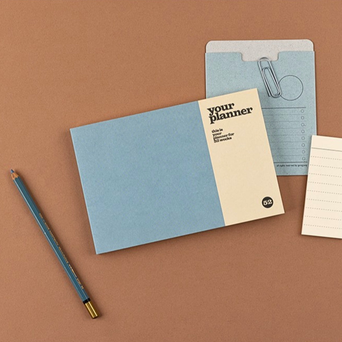 Notebook with a pencil on a brown background