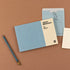 Notebook with a pencil on a brown background