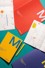 Colorful planner books with a pen on a teal background