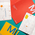 Colorful planner books with a pen on a teal background