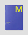 Blue planner with yellow 'M' on a gray background
