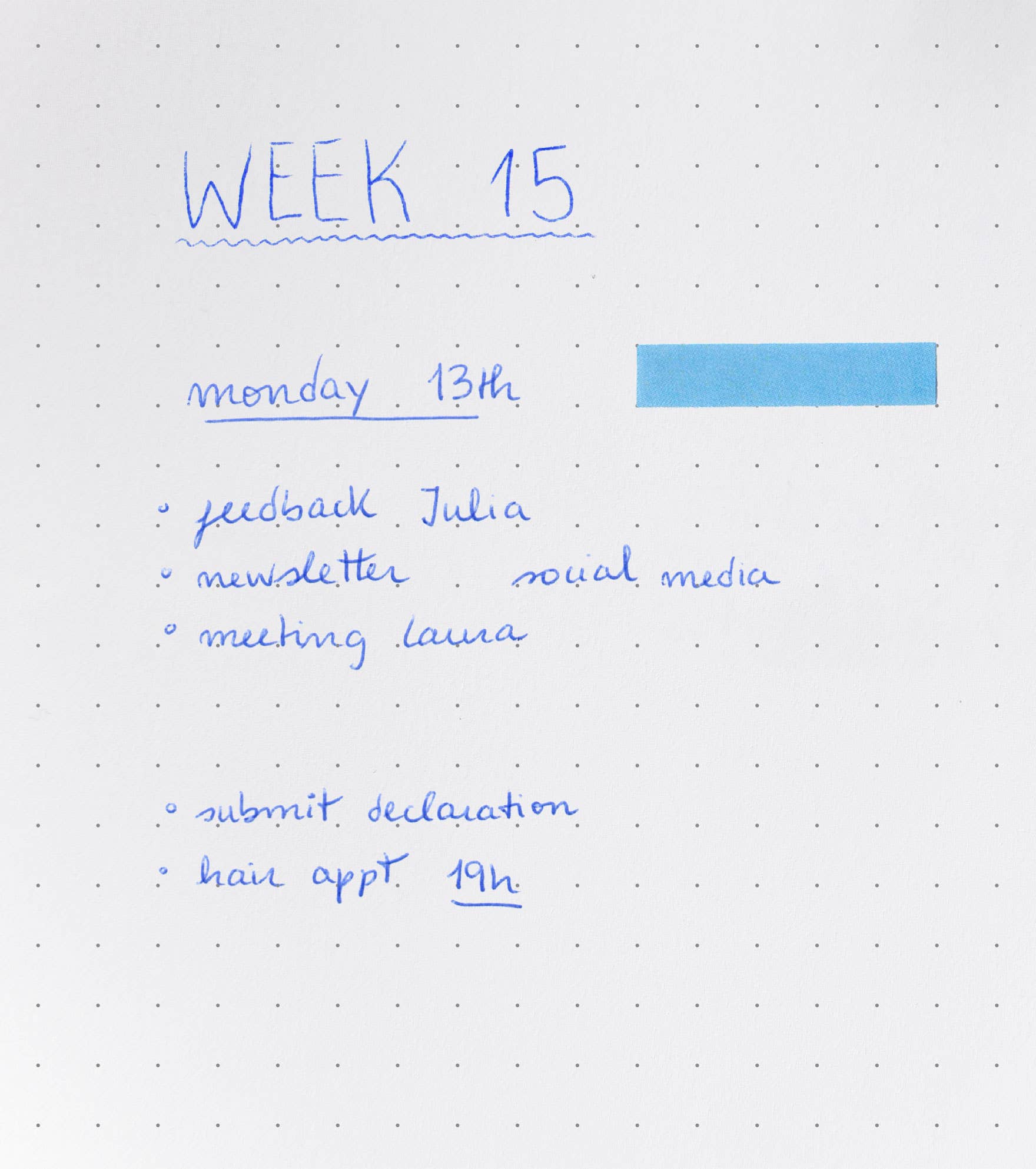 Weekly planner with tasks listed for Week 15 on a dot grid notebook.
