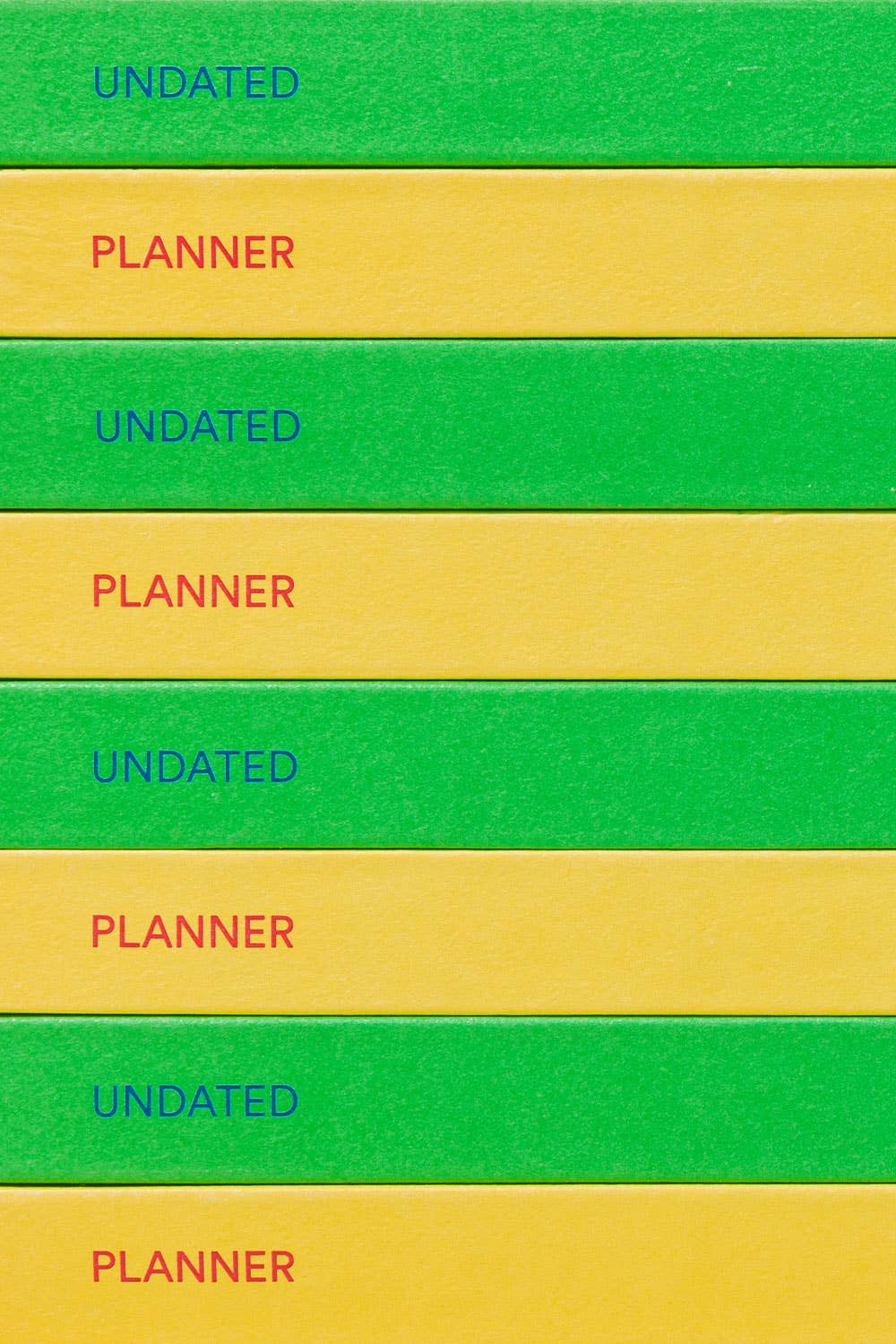 Stack of green and yellow planners with 'Undated Planner' text on each layer.