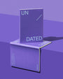 Purple notebook with 'UN' and 'DATED' text on a reflective purple surface