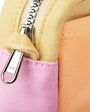 Close-up of a zipper on a multicolored fabric bag with a visible brand logo.