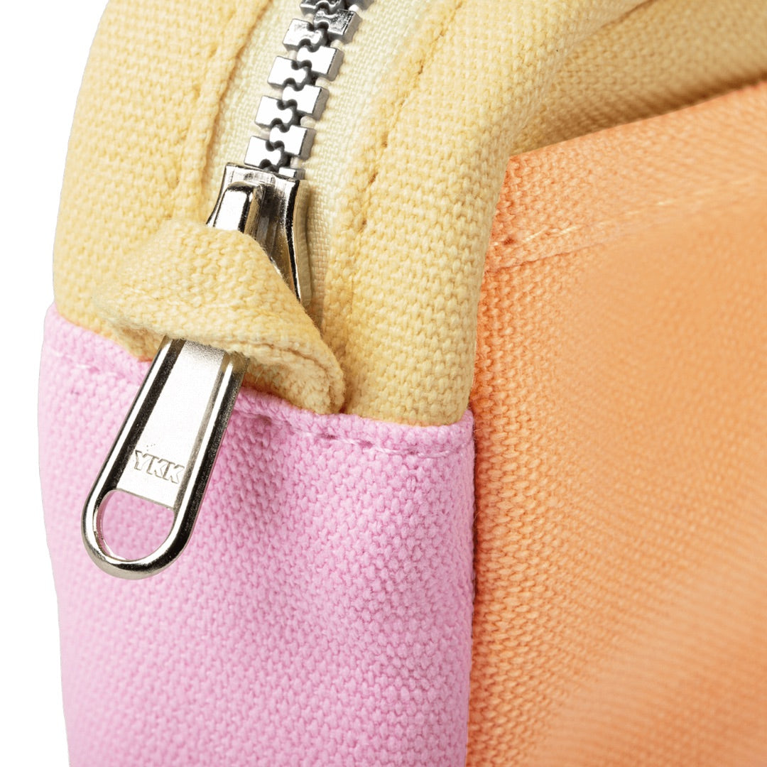 Close-up of a zipper on a multicolored fabric bag with a visible brand logo.