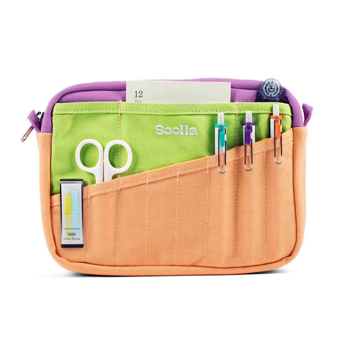 Multicolored organizer bag with scissors and clips on a white background